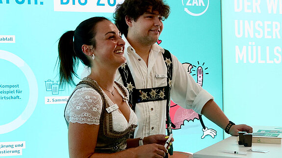 Zwei ZAK Mitarbeiter lächeln am Stand auf der Allgäuer Festwoche © Allgäuer Festwoche